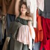 jeune-femme-entouree-piles-vetements_23-2149133931